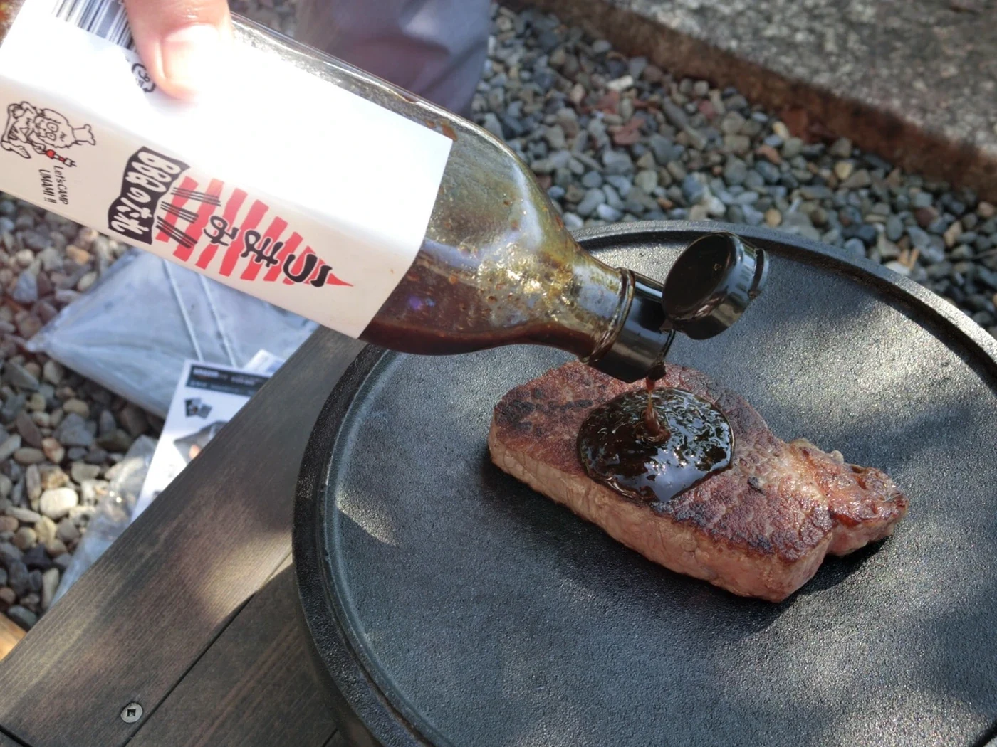 焼き上がったステーキにBBQのたれをかける様子